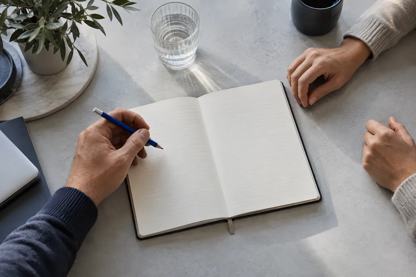 Dos personas conversan frente a un cuaderno abierto